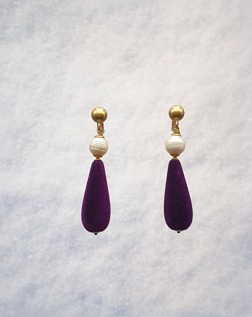golden metal clip-on earrings with pearl and purple velvet drop