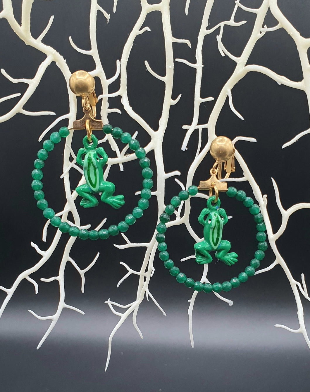 golden metal clip-on with green dyed jade beads and painted tin frogs