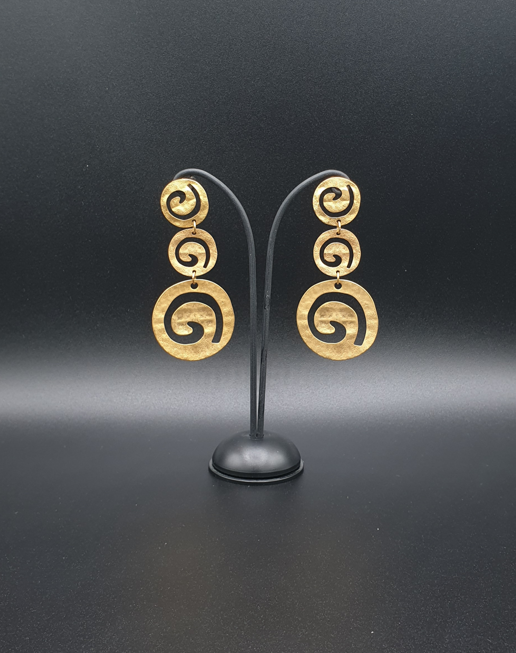 golden metal stud earrings with three decorative circles